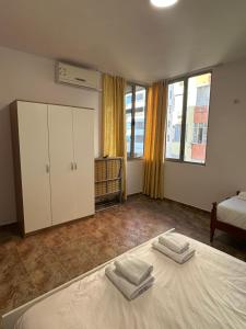 a bedroom with a bed with two towels on it at aldo apartments in Shëngjin +13 photos
