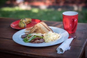 a plate of food with a sandwich and a cup of coffee at Oreteti Mara Lodge in Lolgorien +7 photos