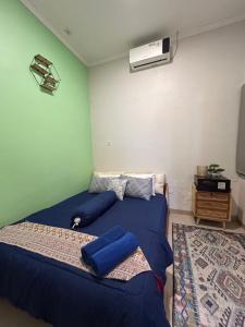 a bedroom with two beds with blue sheets and a heater at Clamitan House Padalarang in Padalarang