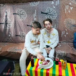 two men standing next to a table with a plate of food at Amazing Lalibela Home stay in Lalibela