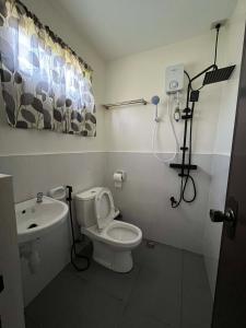 a bathroom with a toilet and a sink at Escubin Travellers Inn in San Miguel