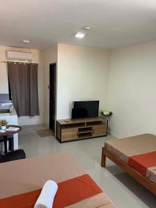 a living room with two beds and a flat screen tv at Escubin Travellers Inn in San Miguel +19 photos