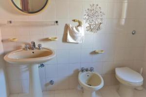 a bathroom with a sink and a toilet and a mirror at Appartamenti Onde Blu in Le Castella +11 photos