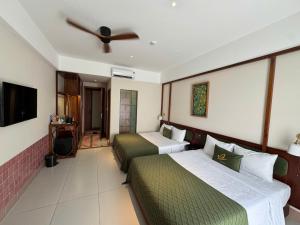 a hotel room with two beds and a ceiling fan at Magnolia Boutique Hue in Thôn Trường Giang