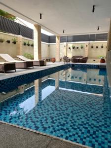a swimming pool with blue tiles in a building at Citistay Apartments in Abuja