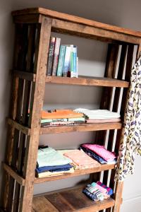 ein Bücherregal mit Büchern und gefalteter Kleidung in der Unterkunft Archavon Studio in St Just