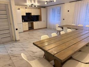 a large room with a wooden table and white chairs at Trostjn house in Slavske