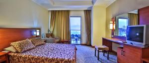 a hotel room with a bed and a flat screen tv at Hedef Resort Hotel in Konaklı
