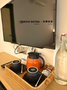 a tray with two cups and a television on a desk at Tokiyo Suites Hotel Kinta River Ipoh Town in Ipoh