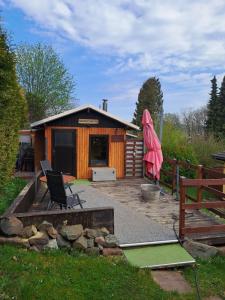 a cabin with a pink umbrella in front of it at Ferienhaus Wanderlust in Waltershausen