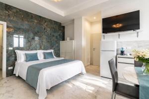 a bedroom with a bed and a table and a refrigerator at White Loft by Symphonya Luxury Holiday Rentals in Gallipoli