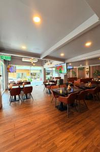 a dining room with tables and chairs in a restaurant at Shwe Ooe Lay Guest House 2 in Pratunam