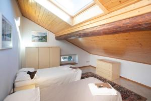 a attic bedroom with two beds and a skylight at ANESI appartamenti in Baselga di Pinè
