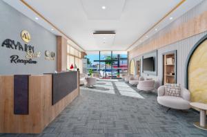 a lobby with a waiting area with chairs and a tv at Arya inn suit in Serik