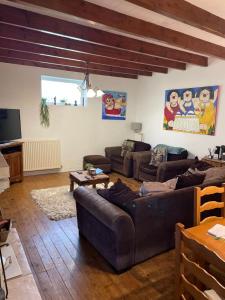 a living room with two couches and a tv at Les Roseries Boutique Gite in Clussais-la-Pommeraie