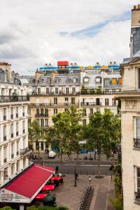 ein großes Gebäude mit rotem Dach in einer Stadt in der Unterkunft Hotel Agora in Paris
