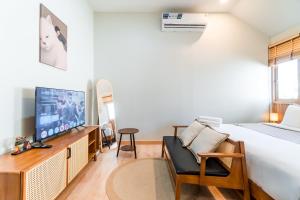a bedroom with a bed and a tv and a chair at Nimman Bed at9 in Chiang Mai