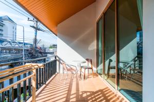 a balcony with a table and chairs on a building at Nimman Bed at9 in Chiang Mai