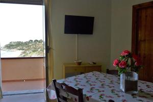 a bedroom with a table with a vase of flowers on it at Appartamenti Onde Blu in Le Castella