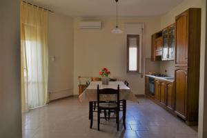 a kitchen and dining room with a table and chairs at Appartamenti Onde Blu in Le Castella