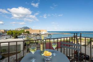 a table with two glasses of wine on a balcony at Sant'Erasmo luxury home in Palermo