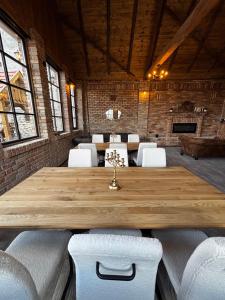 a large wooden table in a room with white chairs at Gémes Vendégház in Vitnyéd