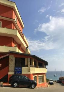 a building with a car parked in front of it at Appartamenti Onde Blu in Le Castella