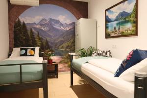 a bedroom with two beds and a mural of a mountain at Old Town Guest Accommodation in Kranj