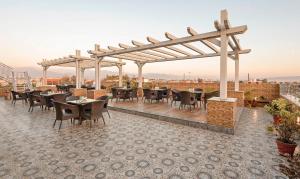 a restaurant with tables and chairs on a roof at Treebo Premium Grand Legacy Elite with Roof Top Cafe in Dehradun