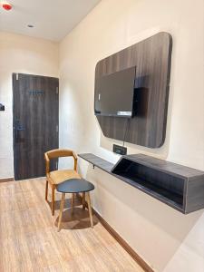 a room with a desk with a tv and a chair at Hotel Presidency - Sosyo Circle in Surat +15 photos