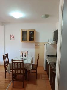 a kitchen with a table and chairs in a room at Apartman SAN in Soko Banja
