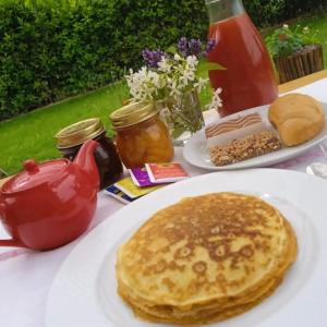a table with a plate of pancakes and tea and jam at In Vino Veritas B&B in Arcola