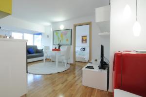 a living room with a couch and a table with a red suitcase at White Dream Suites in Iaşi