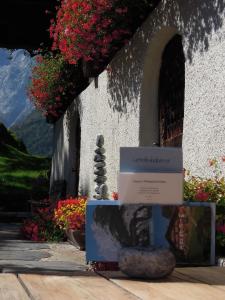 a sign in front of a building with flowers at Landgasthof Tännler in Innertkirchen