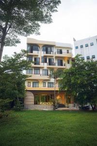 a large apartment building with a lawn in front of it at Magnolia Boutique Hue in Thôn Trường Giang