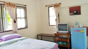 a bedroom with a bed and a tv on a table at Ban Chomdoi บ้านชมดอย in Ban Dong
