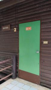 a green door on the side of a building at Ban Chomdoi บ้านชมดอย in Ban Dong