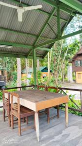 a picnic table under a canopy on a patio at Ban Chomdoi บ้านชมดอย in Ban Dong