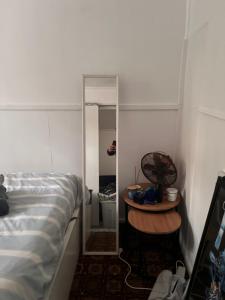 a bedroom with a bed and a table next to a mirror at Tamesis - Wildernest in Neranie