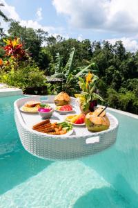 a tray of food on a table next to a pool at Bubble 9 - Luxury Private Pool Experience Ubud in Tampaksiring