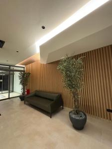 a living room with a couch and trees in it at Komitet Planet Apartment - Free Garage & Modern stay in Niš +22 photos