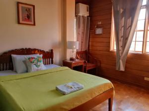a bedroom with a bed with a green blanket at REKWOOD Hotel in Boracay
