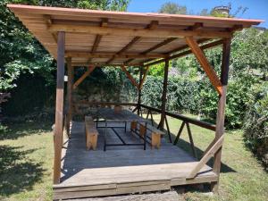a wooden gazebo with a table and benches at Casa Eider in Rucandio