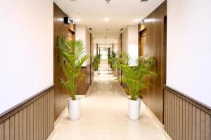 a corridor with potted plants in a hallway at Hotel Kant Palace in Tājganj