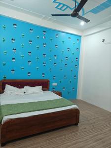a bedroom with a bed and a blue wall at Shri Ram Vila Guest House in Ayodhya