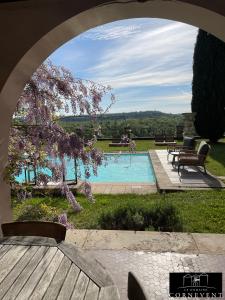 an archway view of a swimming pool with a tree at Appartement scandinave élégant, Domaine Cornevent Lyon, parc & piscine in Vernaison