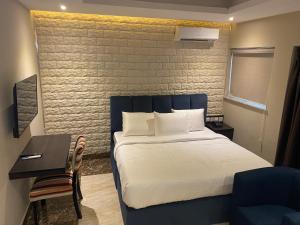 a bedroom with a bed and a desk with a chair at Citistay Apartments in Abuja +13 photos