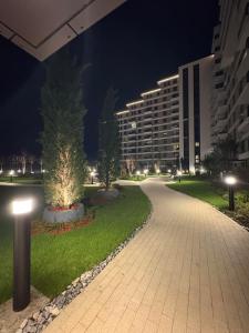 a walkway in a city at night with buildings at Komitet Planet Apartment - Free Garage & Modern stay in Niš