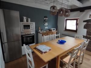 a kitchen with a wooden table and a dining room at Casa Eider in Rucandio