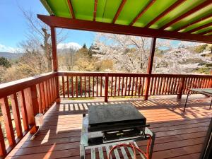 a screened in porch with a table on the deck at りす村別荘 in Yamanakako